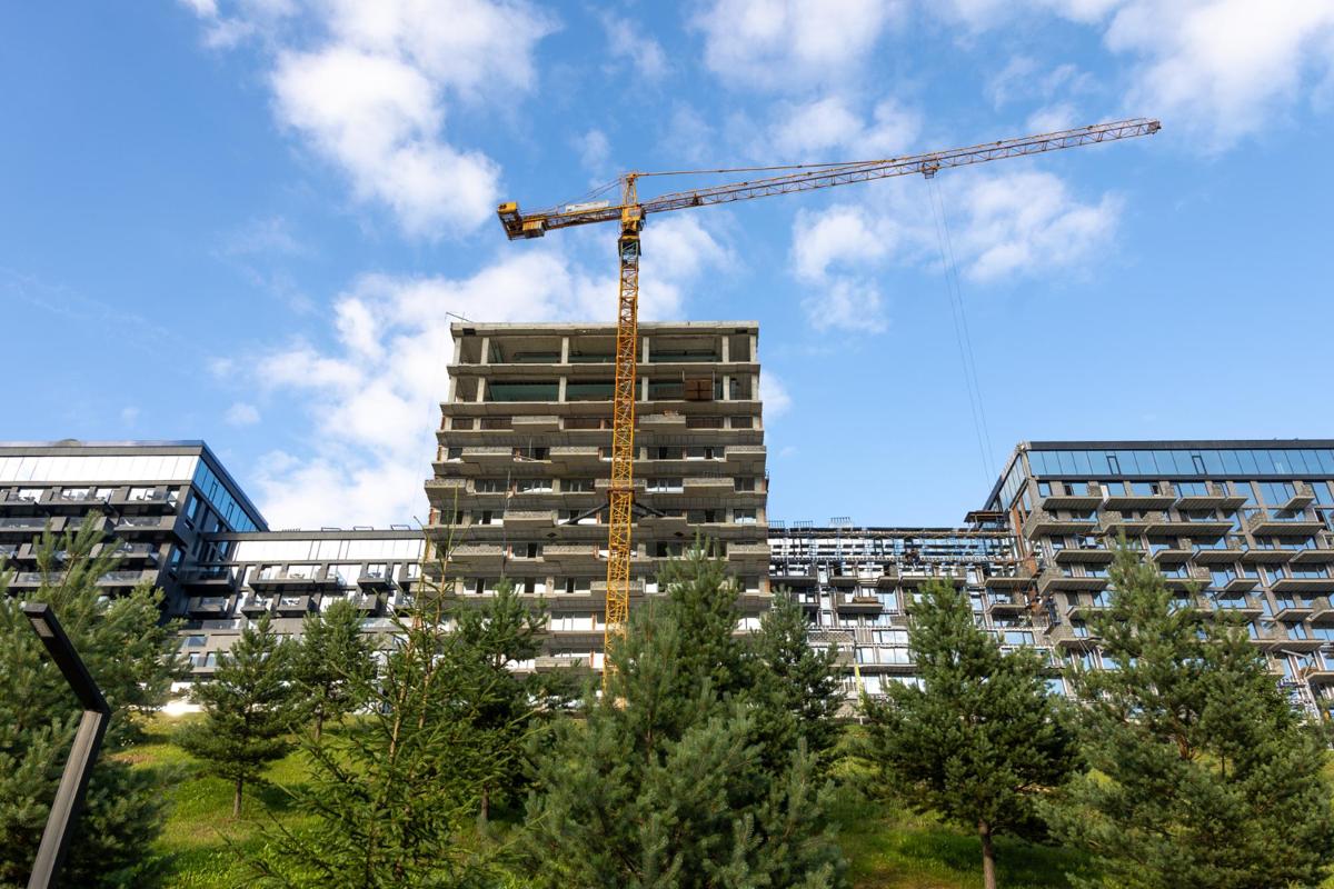 Construction site with tower crane and apartments.