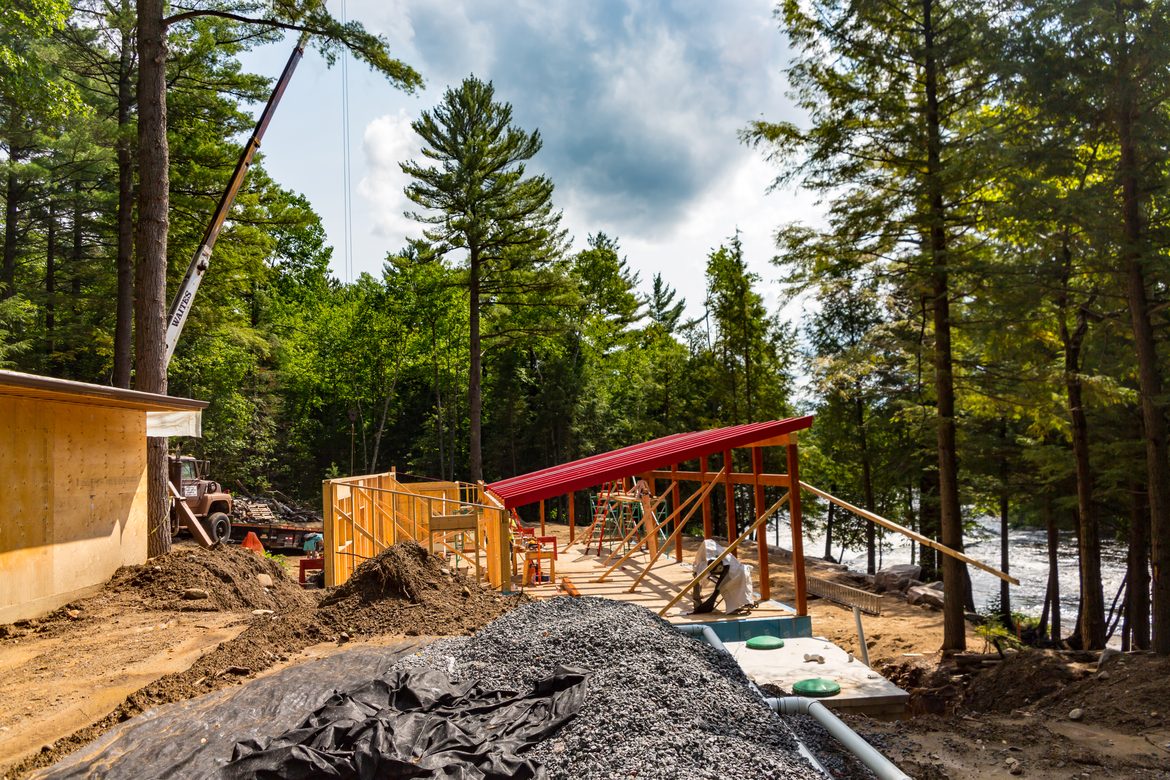 Construction crane building a new cottage in a forest